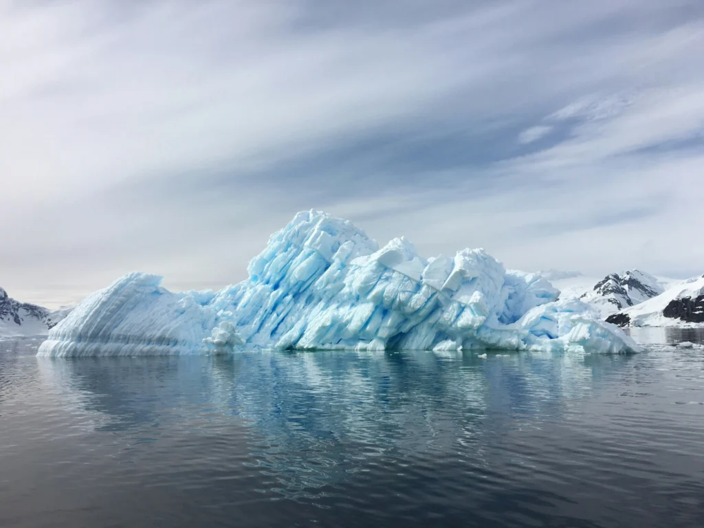 An iceberg floating in open water, symbolizing the hidden depth and submerged emotional layers a writer must uncover during the manuscript revision process