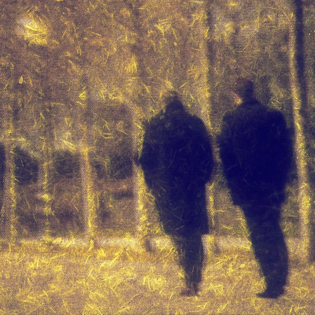 Two anonymous figures walking away through a golden, impressionistic forest, symbolizing the psychological distance writers create between themselves and their autobiographical characters when writing trauma fiction