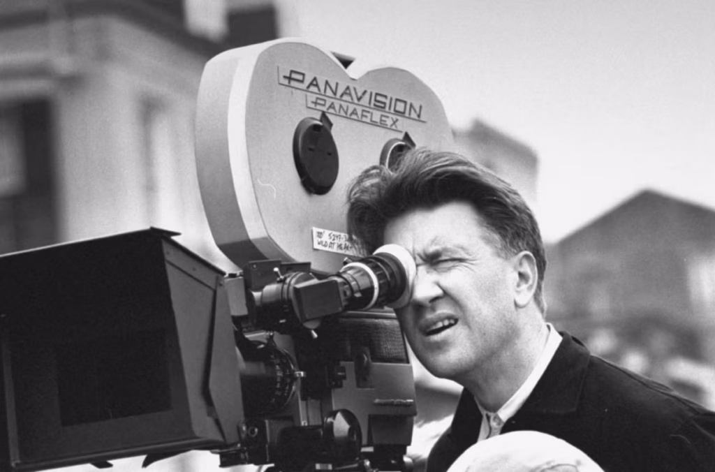 Artist and filmmaker David Lynch behind a film camera on a movie set.